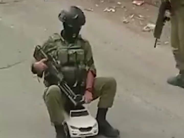 جندي إسرائيلي يمتطي سيارة ألعاب لأطفال فلسطينيين في الضفة الغربية